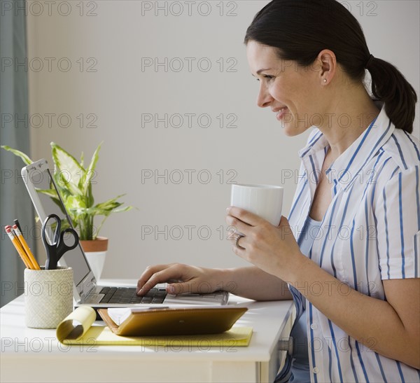 Woman typing on laptop.