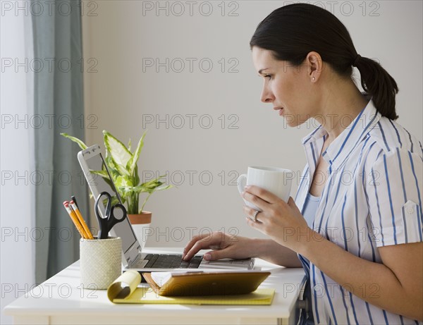 Woman typing on laptop.