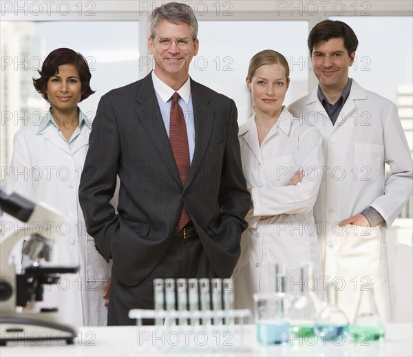 Businessman and scientists in laboratory.