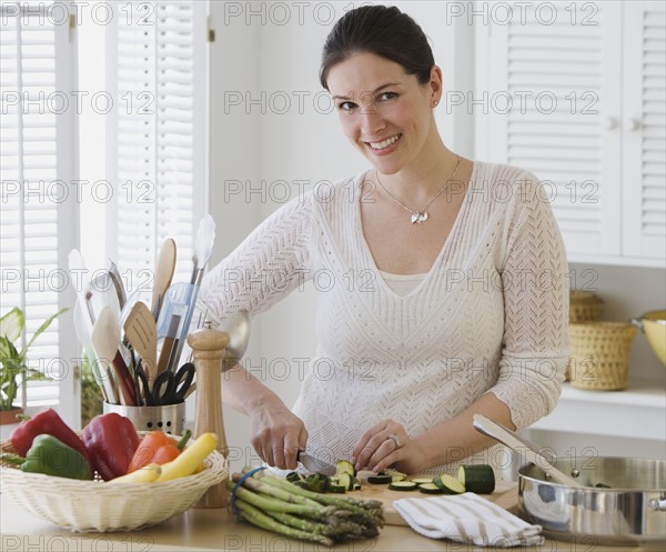 Woman chopping vegetables in kitchen.