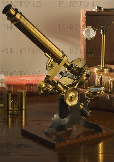 Old fashioned microscope on table.