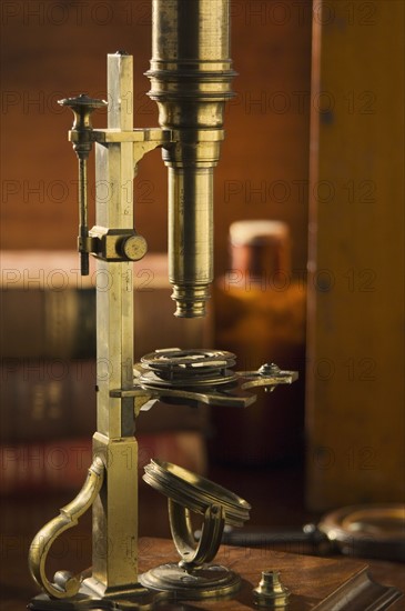 Old fashioned microscope on table.