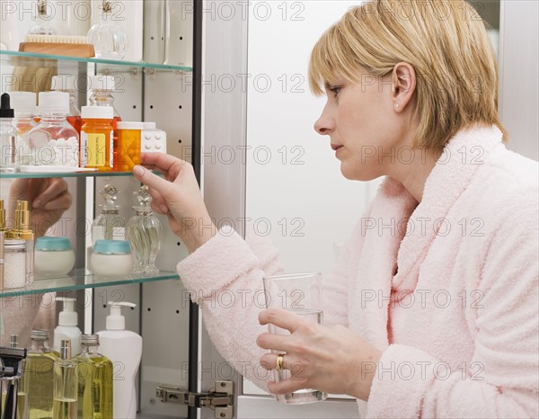 Woman looking in medicine cabinet.