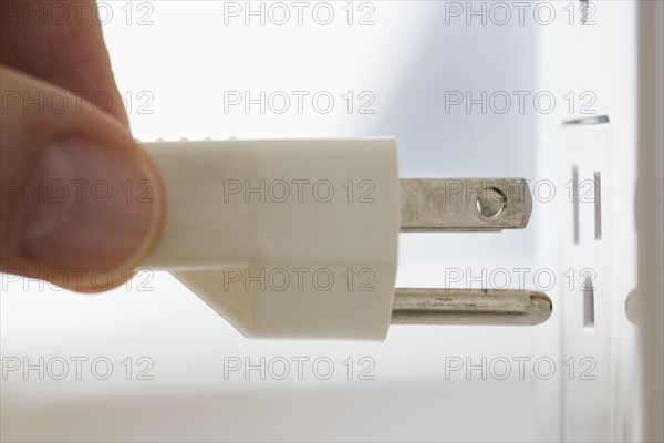 Close up of plug next to outlet.