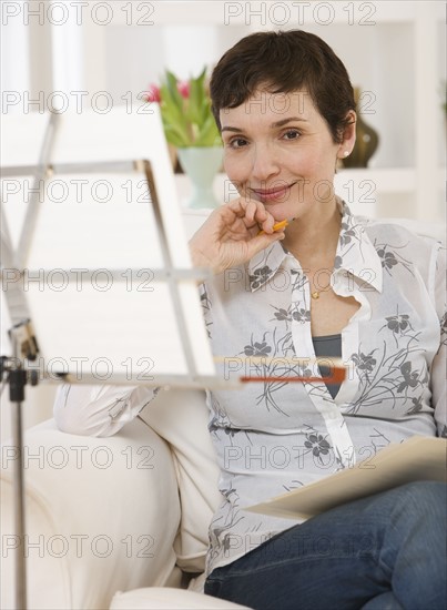 Woman sitting next to sheet music on stand.