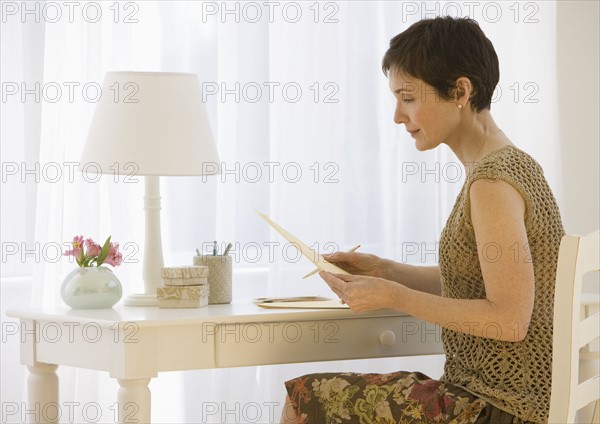 Woman writing letter at desk.