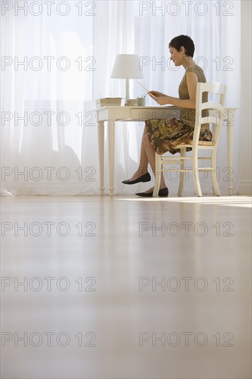 Woman writing letter at desk.