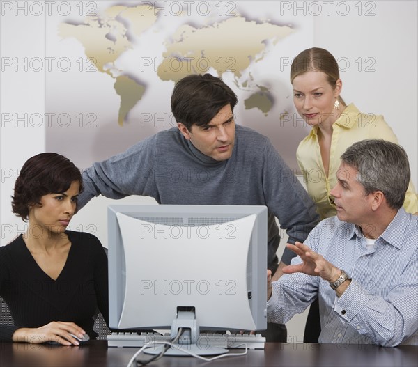 Group of businesspeople looking at computer.