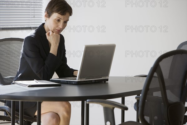 Businesswoman looking at laptop.