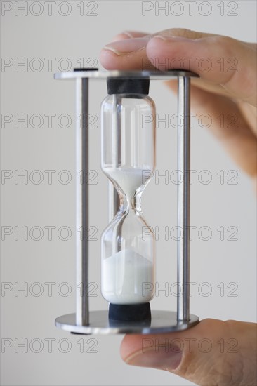 Man holding small hourglass.