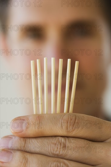 Man holding toothpicks.