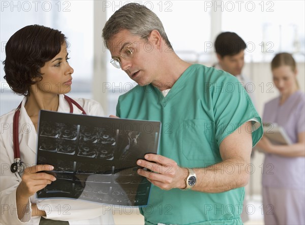 Male and female doctors looking at x-ray.