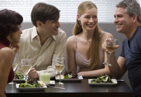 Two couples eating at restaurant.