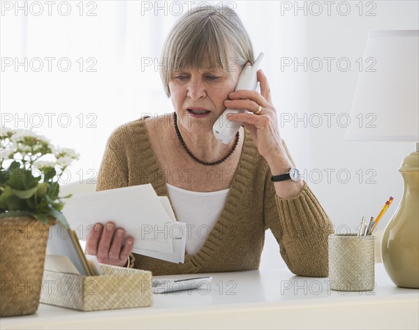 Senior woman looking at bills.