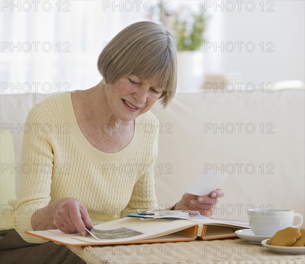 Senior woman looking at photo album.