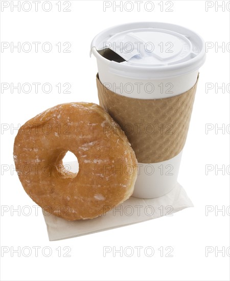 Coffee in to go cup next to doughnut.
