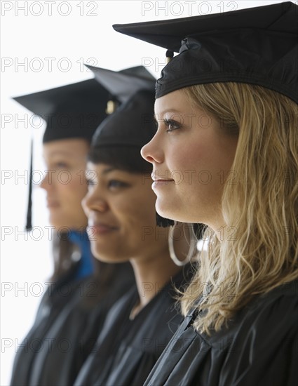 Multi-ethnic women wearing graduation cap and gown.