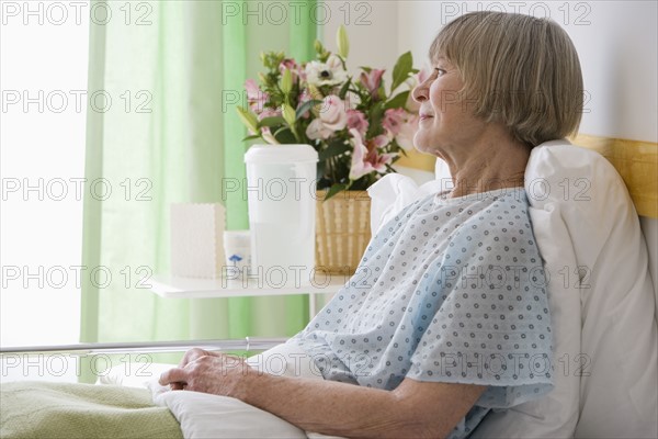 Senior woman laying in hospital bed.