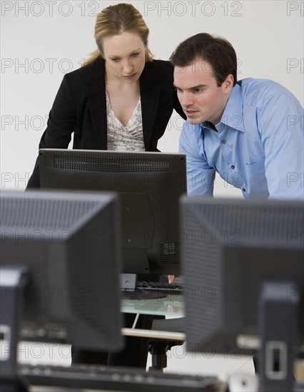 Businesspeople looking at computer.