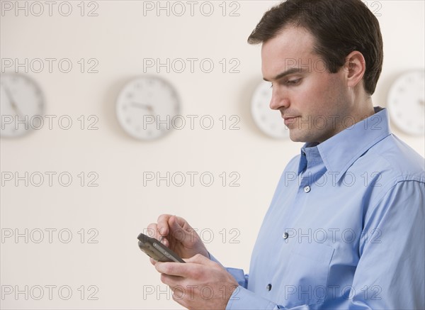 Businessman using electronic organizer.