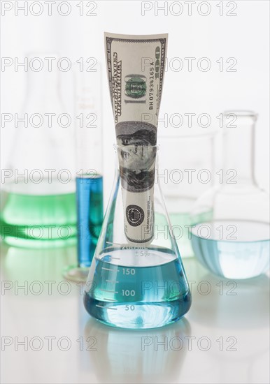 Close up of beakers and money.