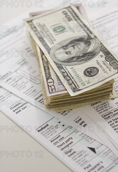 Stack of money on tax forms.