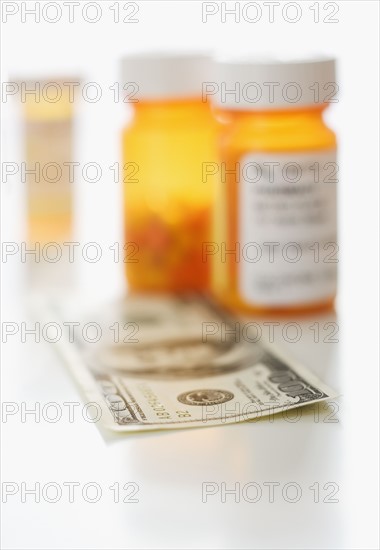 Money in front of medication bottles.