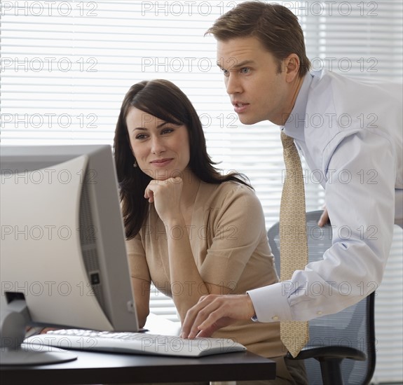 Businesspeople looking at computer.