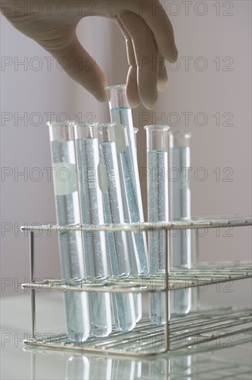 Scientist taking vial out of rack.