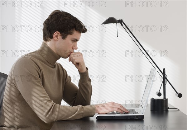 Businessman typing on laptop.