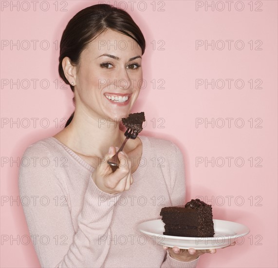 Portrait of woman eating cake.
