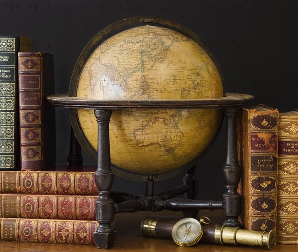 Old fashioned globe and books on table.