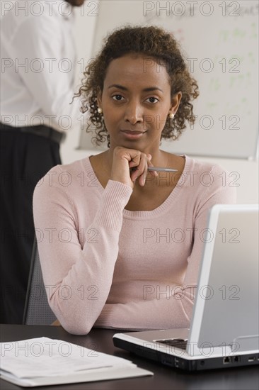 Portrait of businesswoman next to laptop.