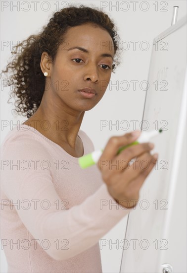 Businesswoman writing on whiteboard.