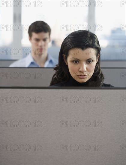 Businesspeople working in cubicles.