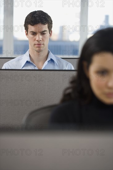 Businesspeople working in cubicles.