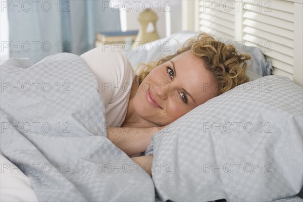 Portrait of woman laying in bed.