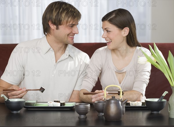 Couple smiling at each other at Japanese restaurant.