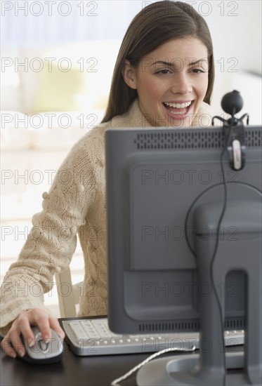Woman smiling at webcam on computer.