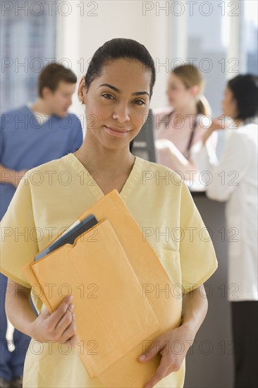 Portrait of female doctor holding files.