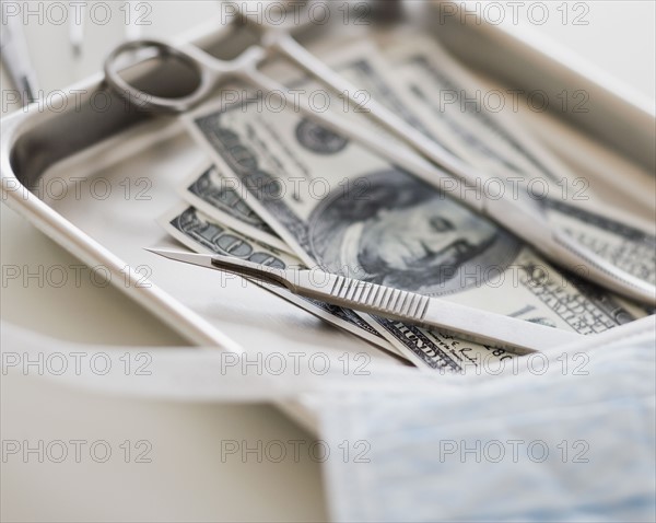 Close up of surgical tools and money.