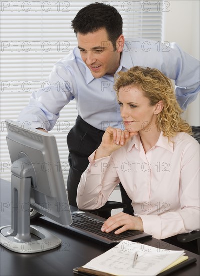 Businesspeople looking at computer.