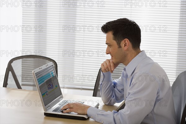 Businessman typing on laptop.