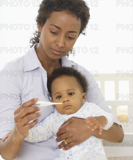 Mother taking baby’s temperature.