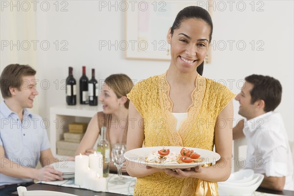 Portrait of woman holding plate of food.