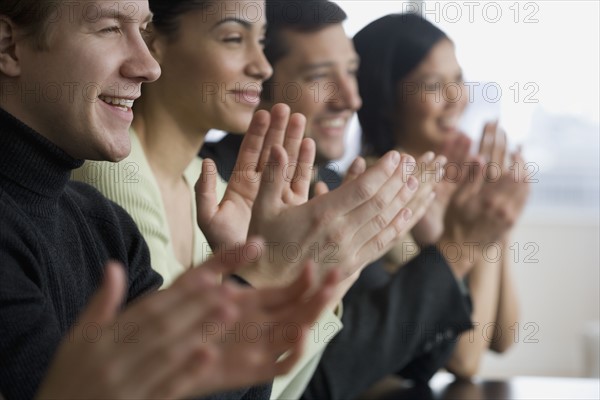 Group of businesspeople clapping at meeting.