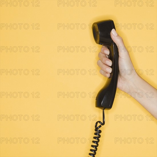 Woman holding telephone receiver.