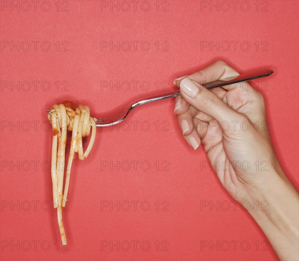 Woman holding forkful of pasta.