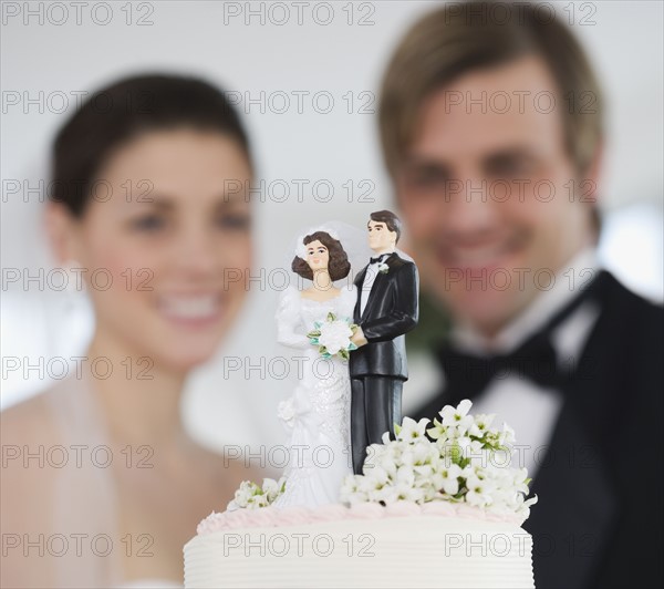 Bride and groom smiling at wedding cake.