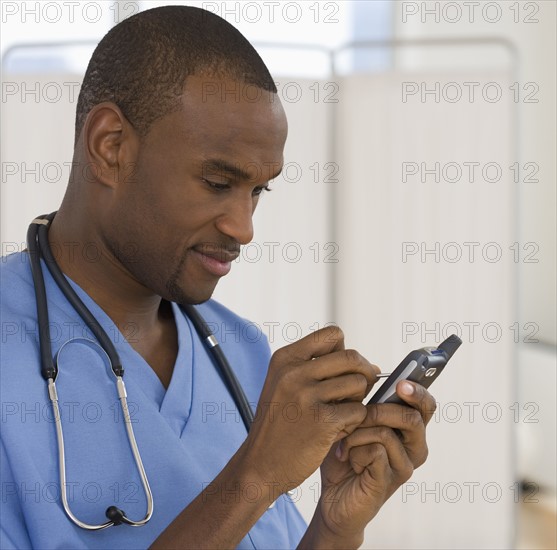 Male doctor using electronic organizer.